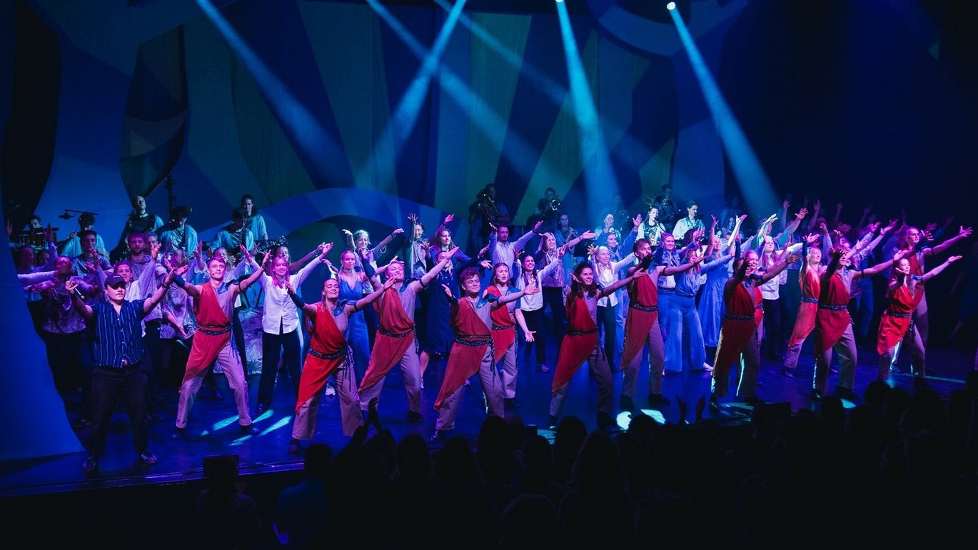På billedet ser man scenen i Hermans, Tivoli Friheden, hvor 25 skuespillere (medicinstuderende) står på scenen badet i spotlight.